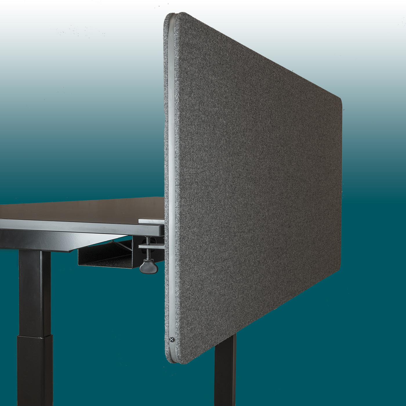 Dark grey EDGE desk back panel with a felt surface and rounded rubber edge, clamped to the side of a black desk top. The vertical soundproof partition on the office desk with a black frame reduces noise.